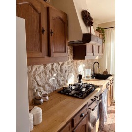 Otwarta strefa dzienna z kamieniem Bokara Rock Face na głównej ścianie - beżowy kamień połączony z drewnem w kuchni